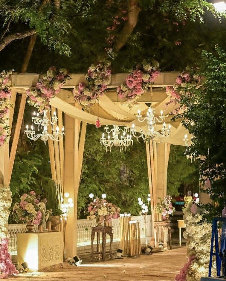 Candlelit floral walkway under the trees